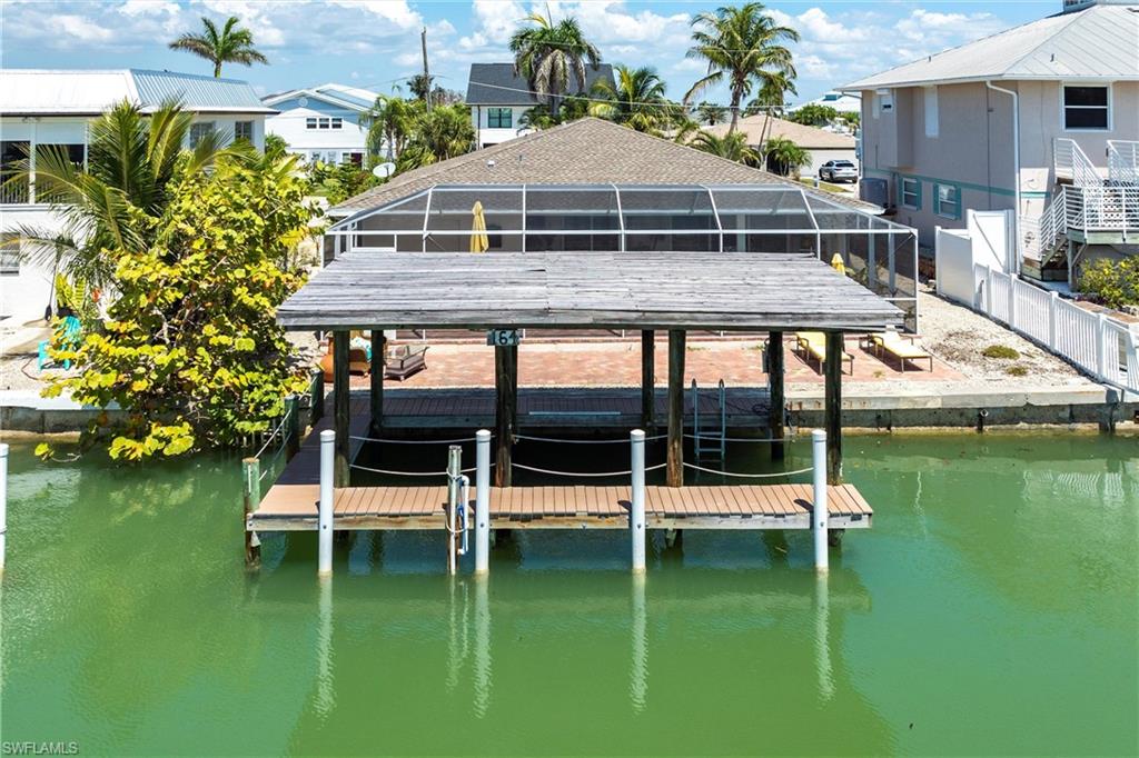 View of dock with a lanai, a residential view, and a water view