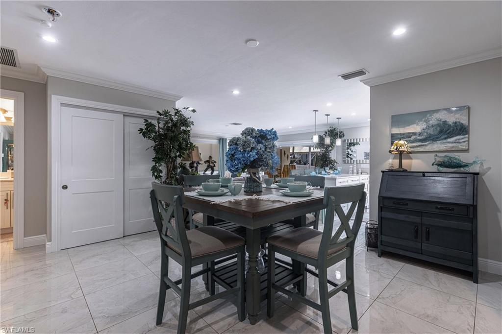 Dining space with recessed lighting, ornamental molding, baseboards, marble finish floor