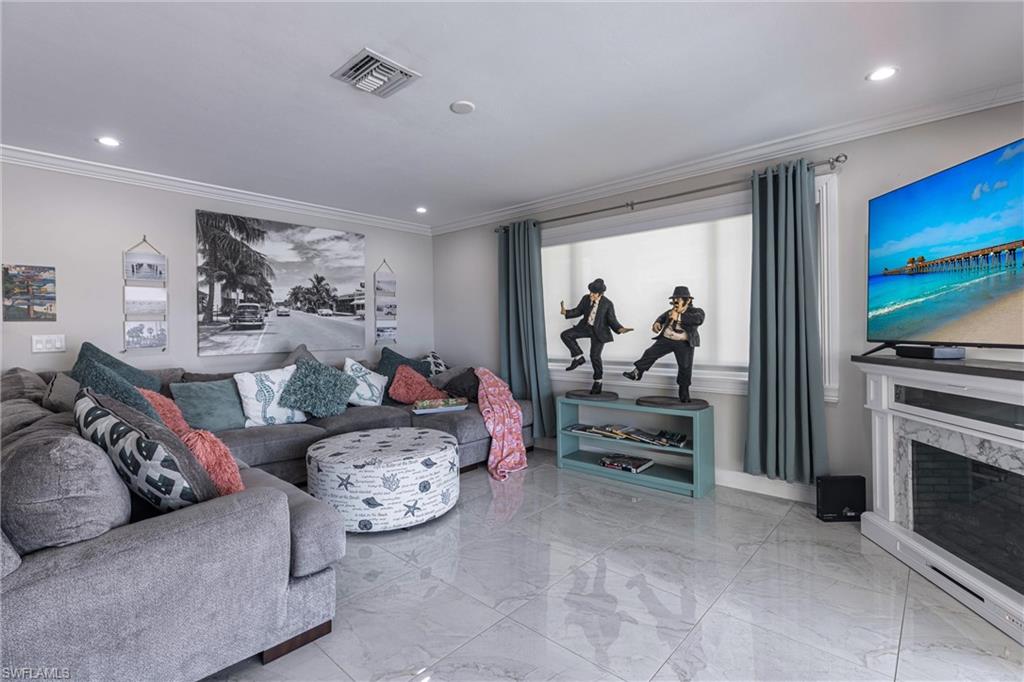 Living area with marble finish floor and crown molding