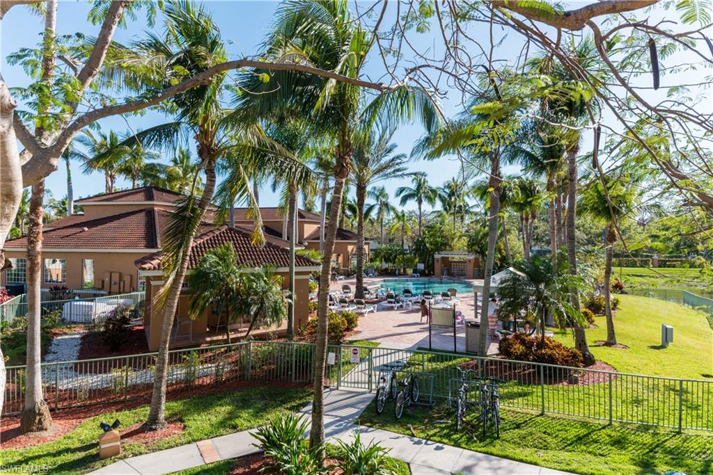 Surrounding community with a fenced front yard, a pool, and a gate