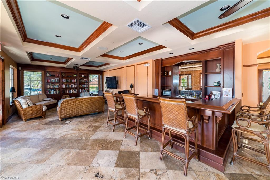 Bar area featuring ceiling fan, crown molding, plenty of natural light, coffered ceiling, and open shelves