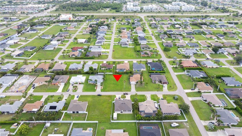 Aerial view of property and surrounding area with nearby suburban area