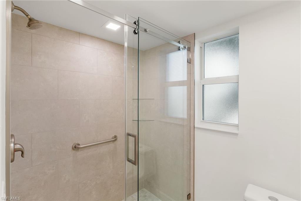 Primary bathroom featuring a shower stall and toilet