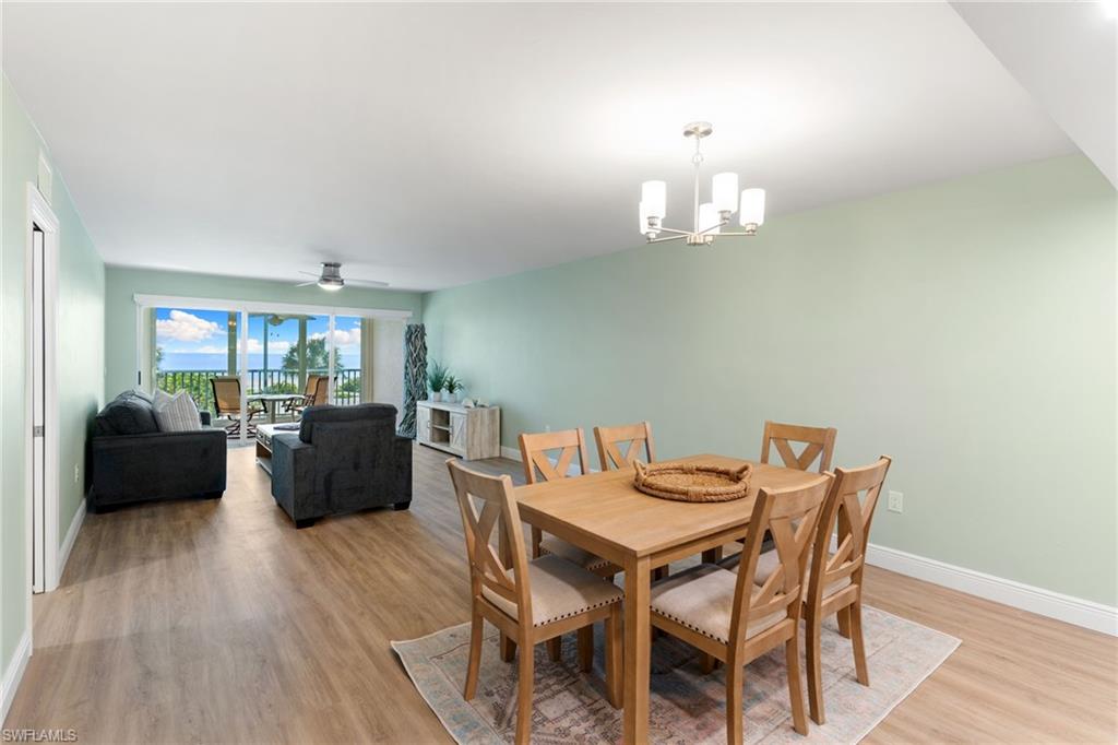 Dining room featuring light wood-style floors, a chandelier, and ceiling fan