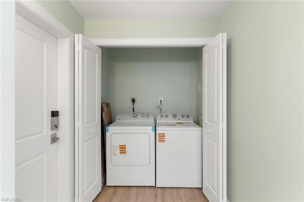 Laundry area featuring light wood-style floors and washer and dryer