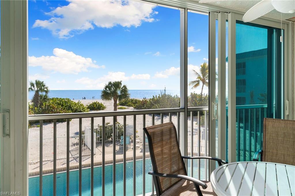 Sunroom with a water view and view of pool