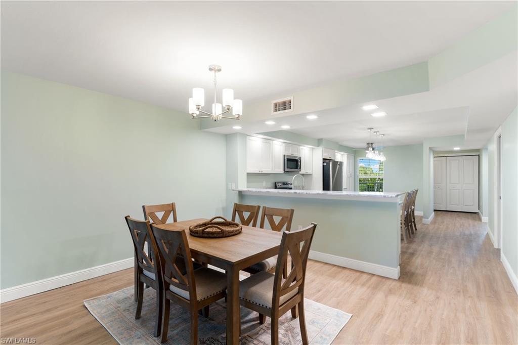 Dining space with a chandelier, light wood-type flooring, and recessed lighting