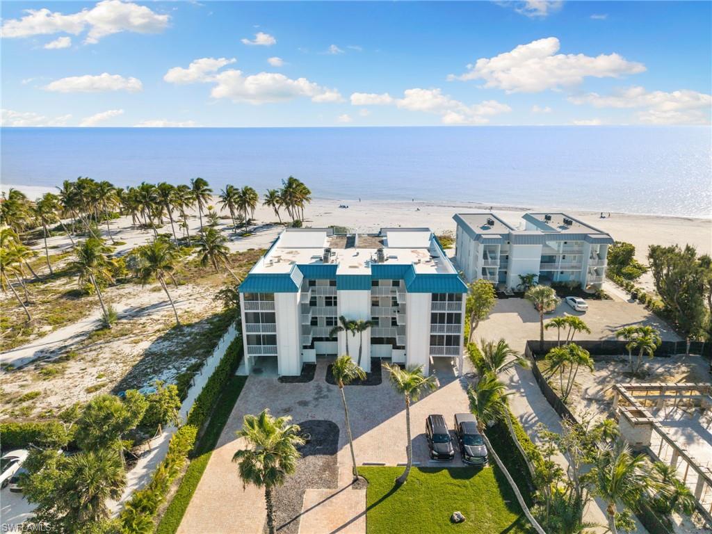 Drone / aerial view of apartment complex / building and waterfront with a beach