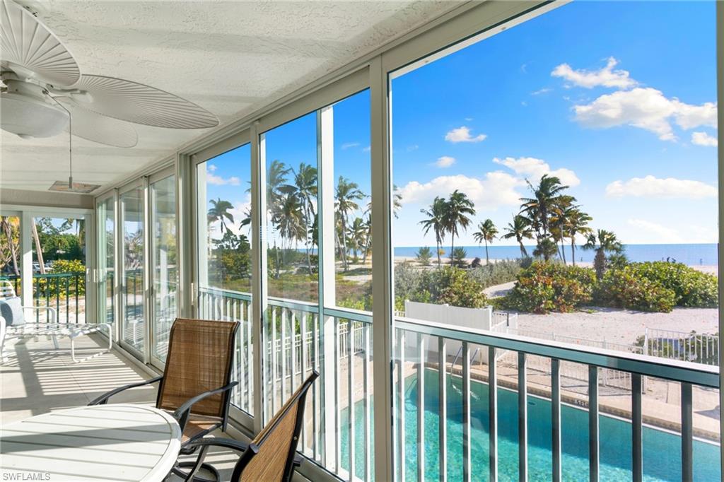 Sunroom / solarium featuring a textured ceiling, floor to ceiling windows, and a water view