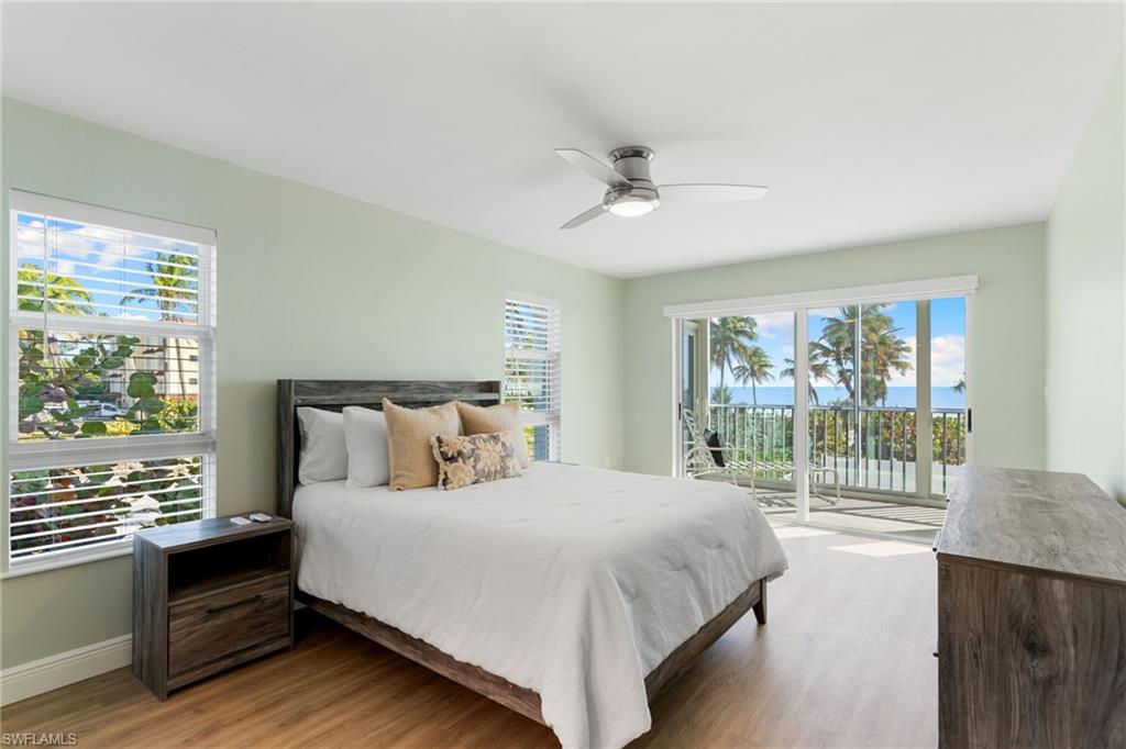 Primary Bedroom featuring access to outside, wood finished floors, and a ceiling fan