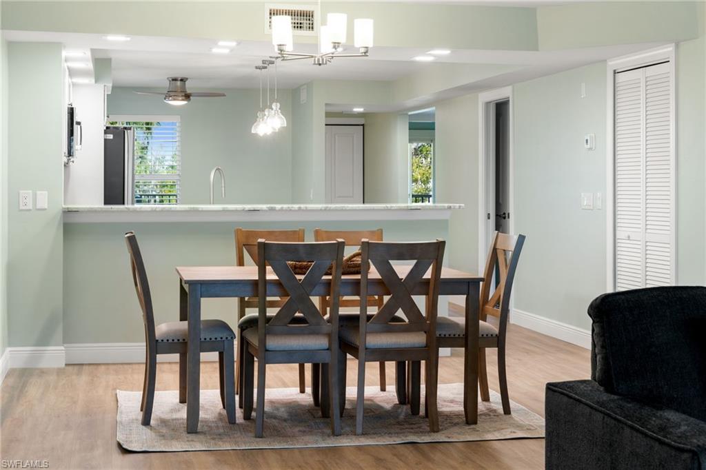 Dining space featuring light wood-style floors, recessed lighting, and a chandelier