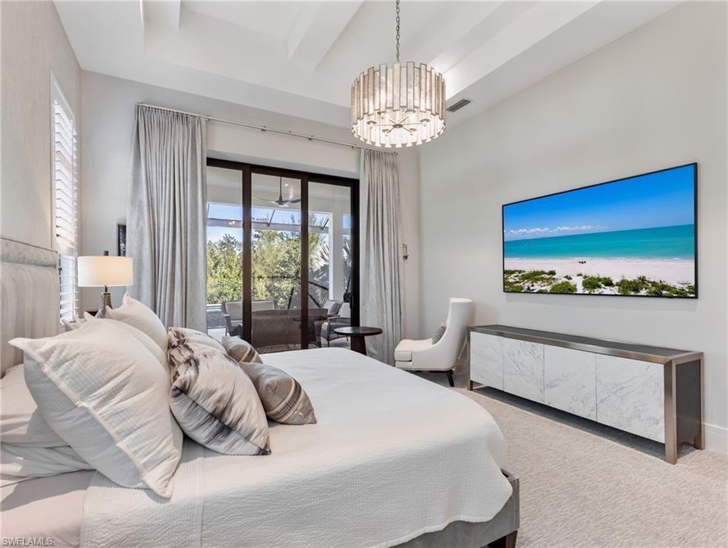 Bedroom with access to exterior, carpet floors, and a chandelier