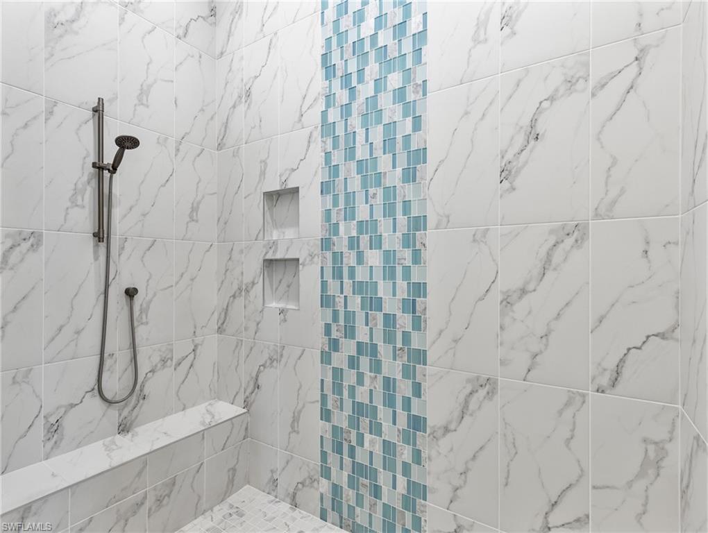 Full bath featuring a marble finish shower