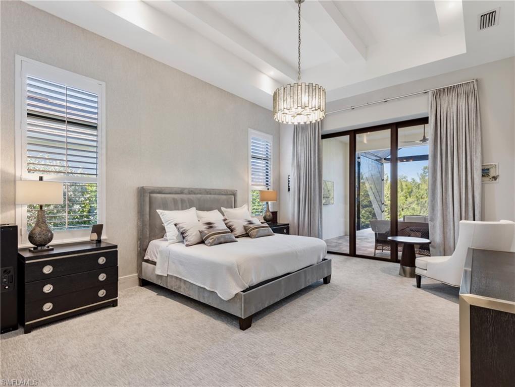 Bedroom featuring light colored carpet, access to exterior, a chandelier, and a raised ceiling