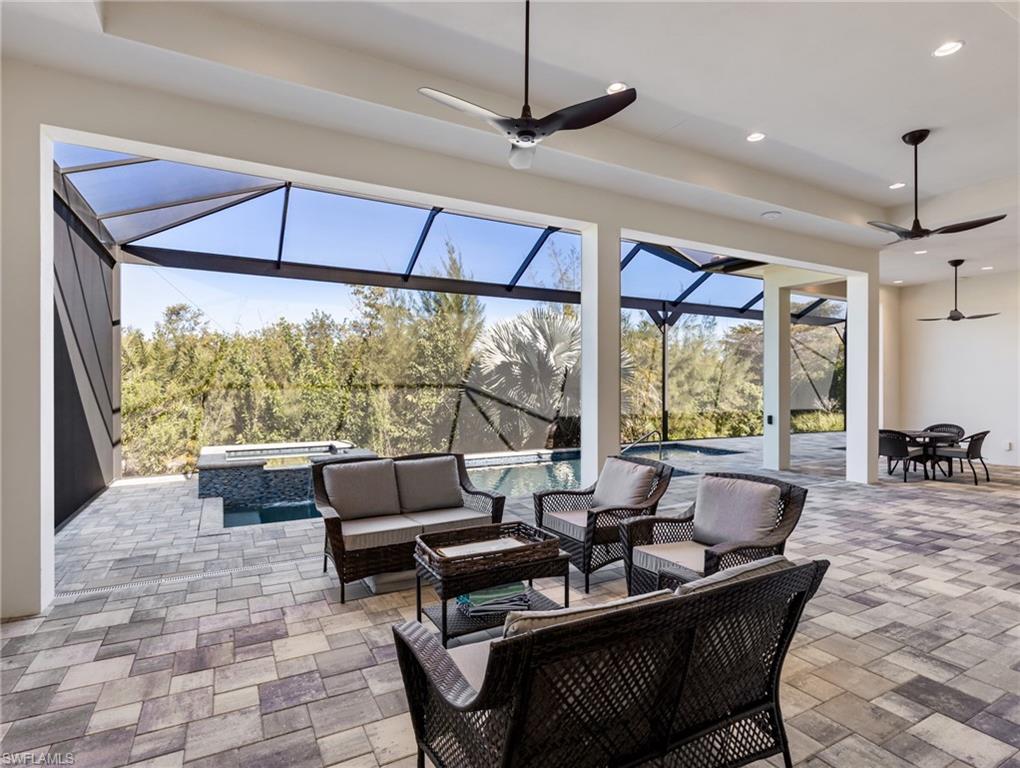 View of patio featuring ceiling fan, an outdoor living space, a sunroom, glass enclosure, and a pool with connected hot tub