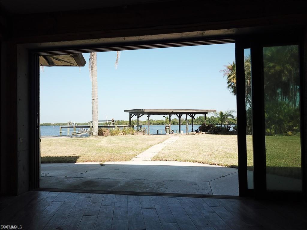 Dock area featuring a water view, a patio, and a yard