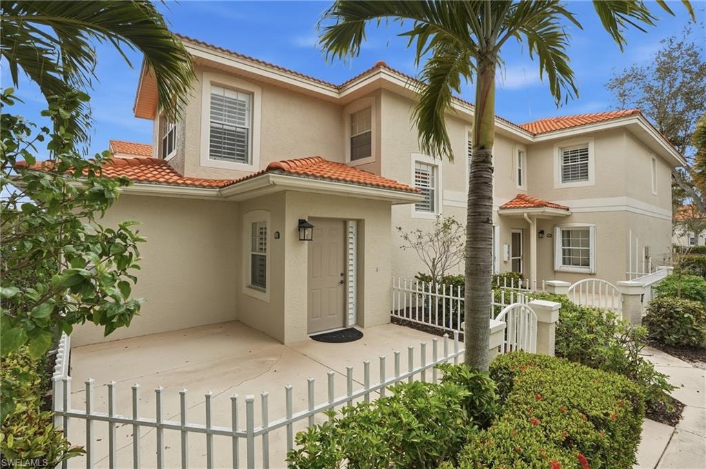 Mediterranean style condo with a tile roof and stucco siding