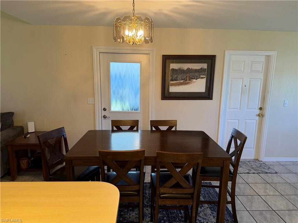 Dining room with light tile patterned floors and a chandelier