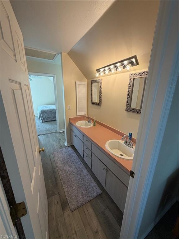 Bathroom featuring double vanity, dark wood finished floors, and ensuite bathroom