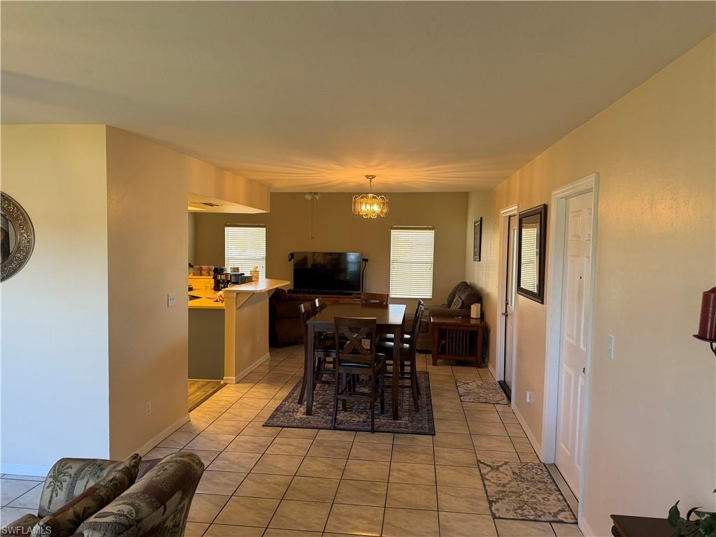 Dining area featuring light tile patterned flooring and a chandelier