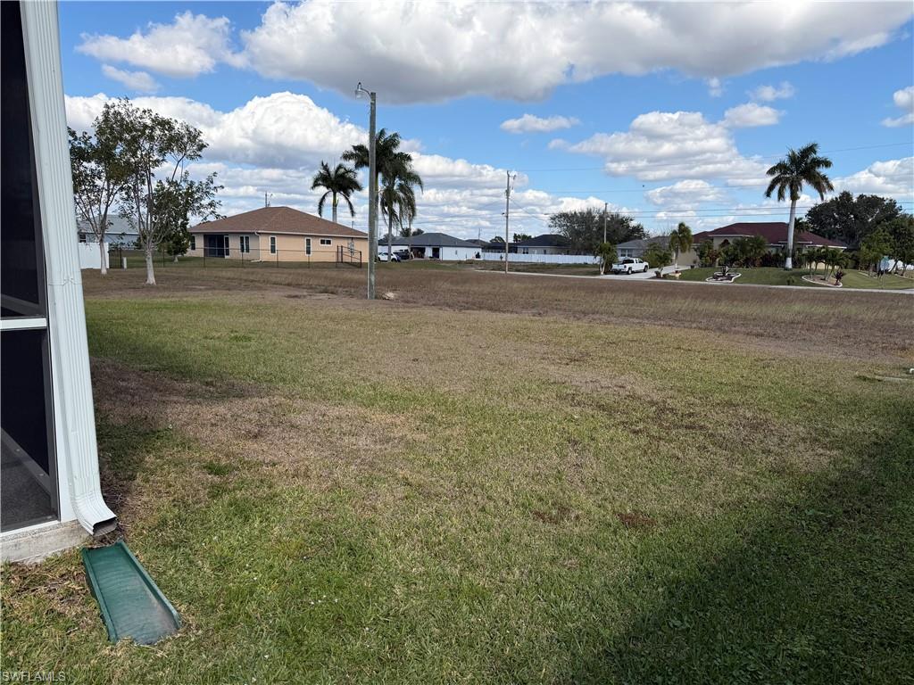 View of green lawn featuring a residential view