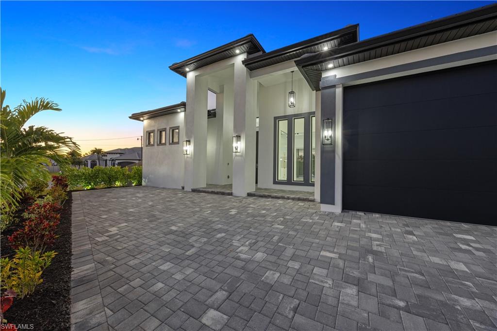 Entrance to property with an attached garage and stucco siding