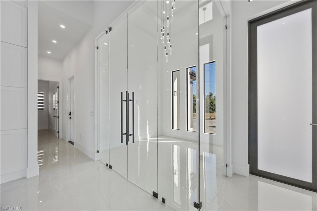 Hall with recessed lighting and a towering ceiling