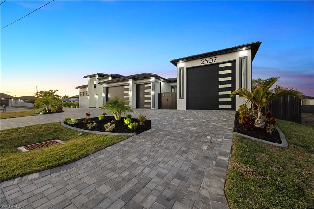 Contemporary house with an attached garage, decorative driveway, and stucco siding