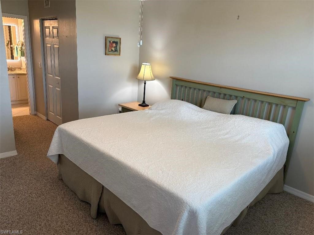Bedroom with walk in his and hers closets, night stand with lamp.