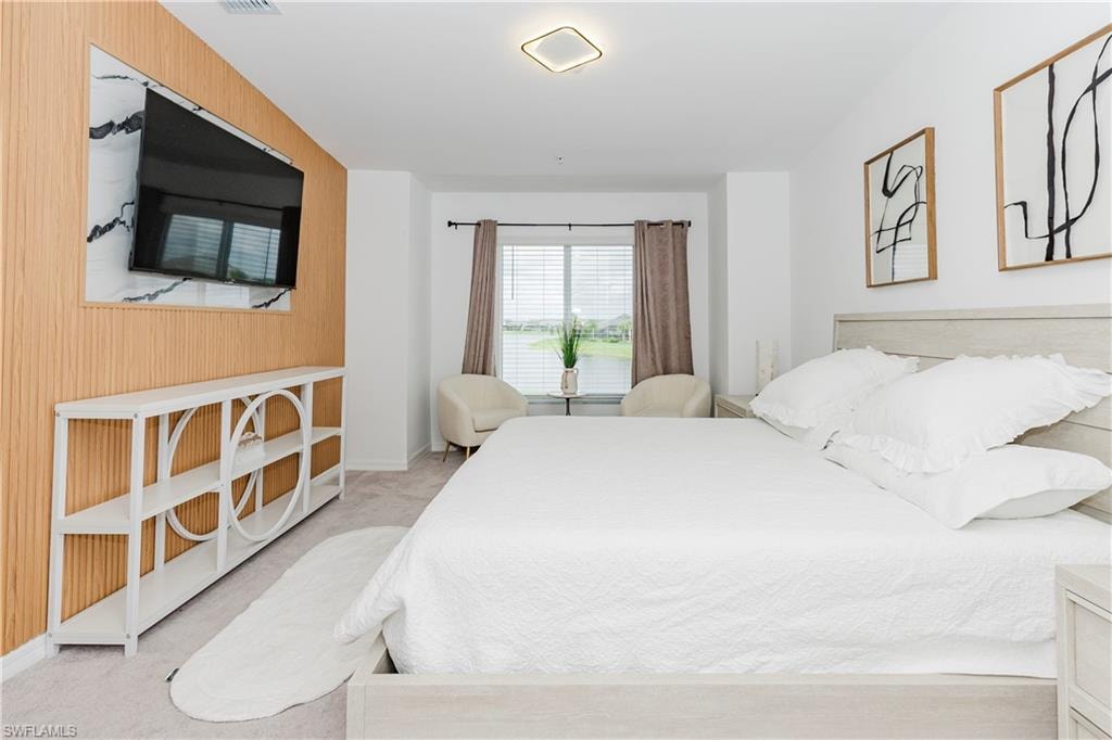 Bedroom with carpet, wooden walls, and baseboards