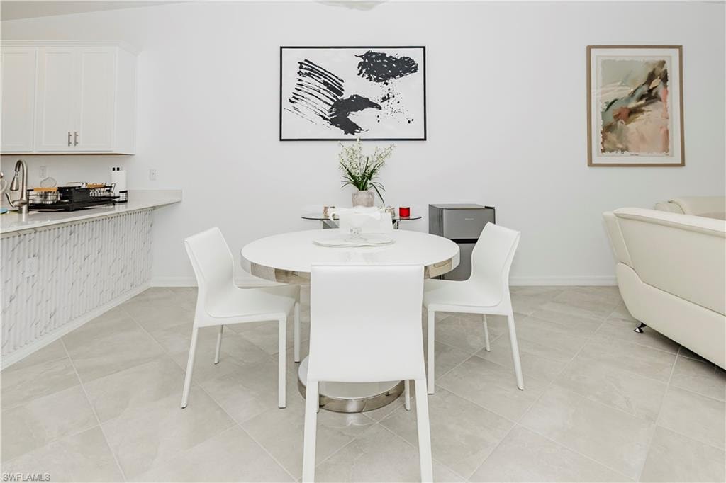 Dining area with baseboards and light tile patterned flooring
