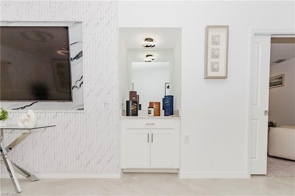 Hallway with baseboards, light tile patterned flooring, and wallpapered walls