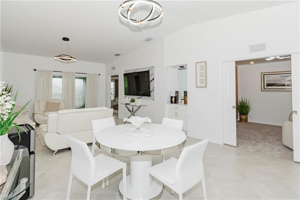 Dining space with lofted ceiling, an accent wall, and baseboards