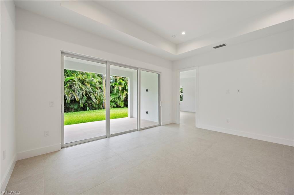 Empty room with a raised ceiling and recessed lighting