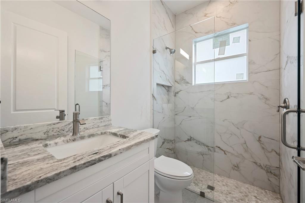 Full bathroom with a marble finish shower and vanity