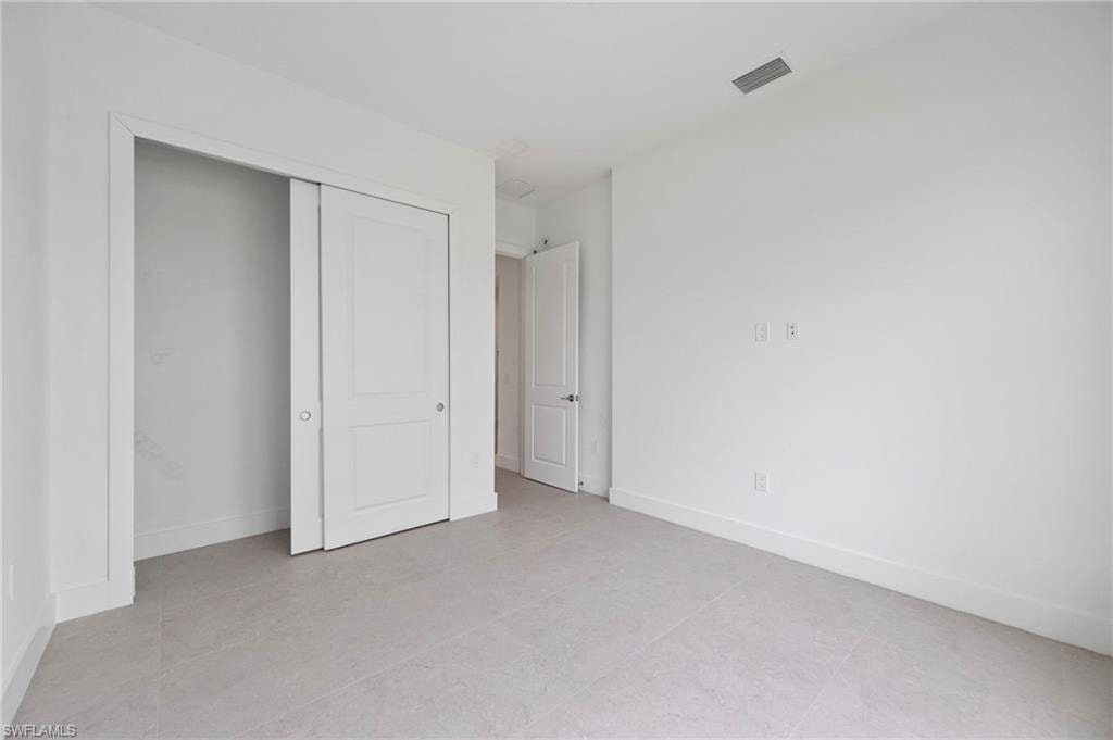 Unfurnished bedroom with a closet and baseboards