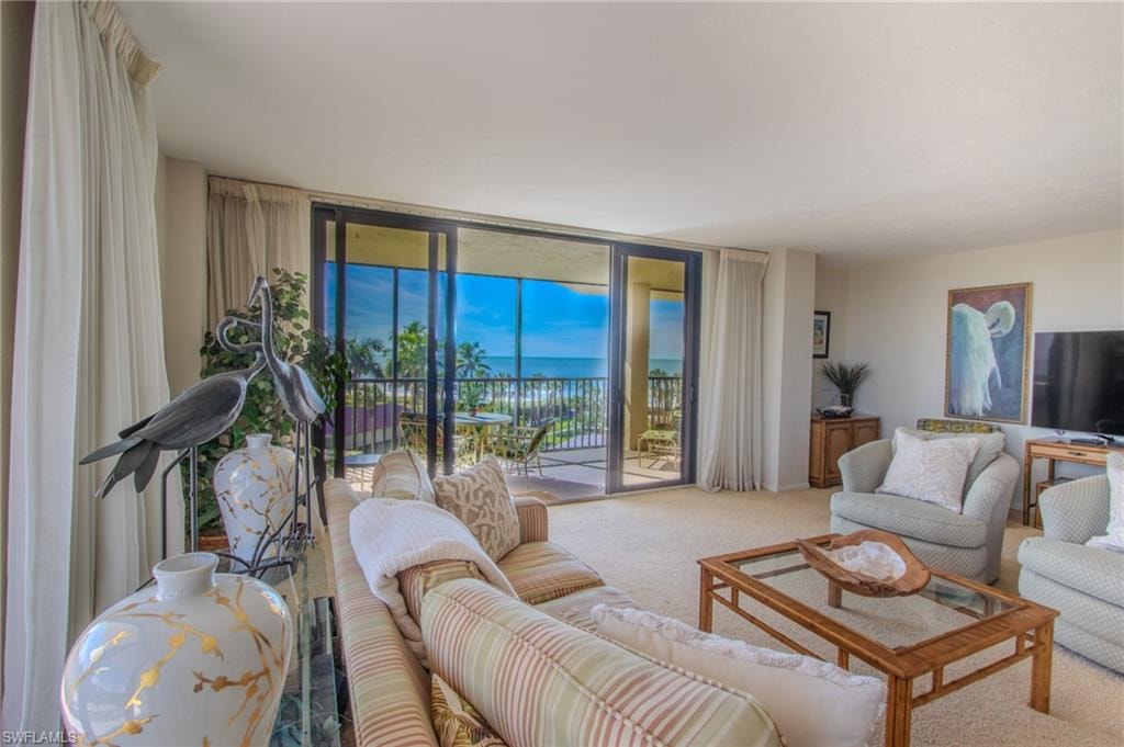 Spacious living area with sweeping Gulf views and access to the wraparound lanai.