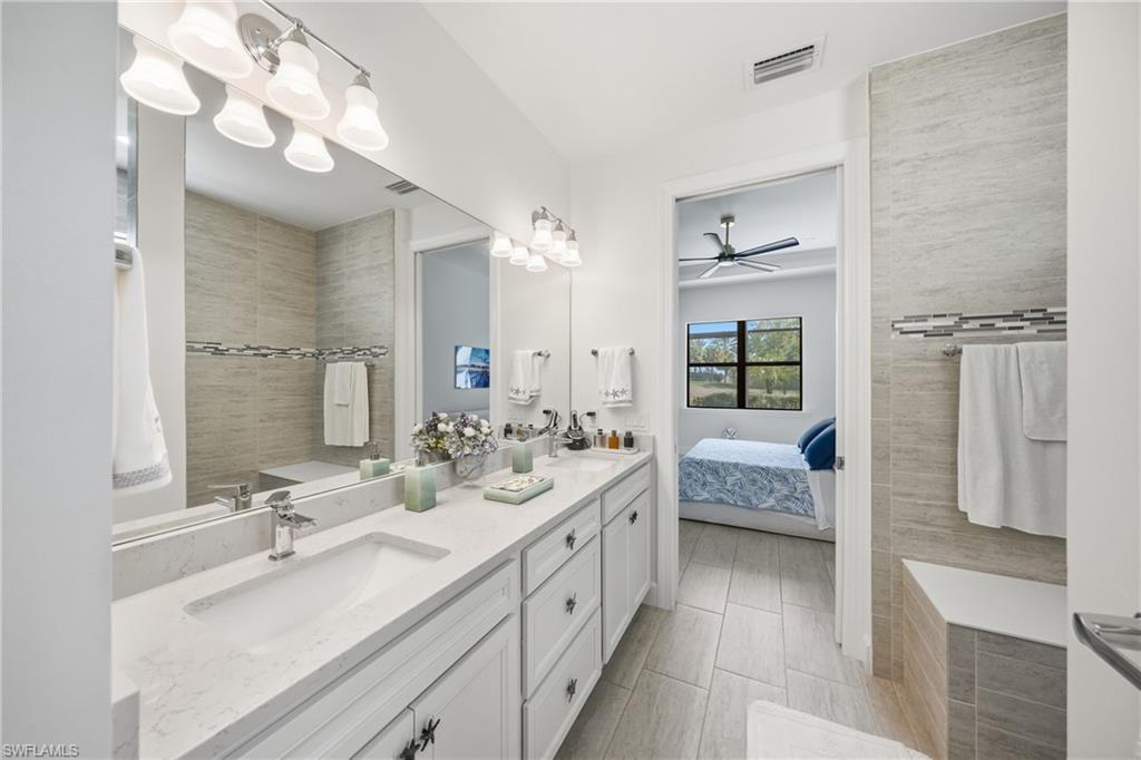 Spacious primary bath offering dual vanities, updated lighting, and a bright, refreshed feel that complements the home’s overall move-in-ready condition.