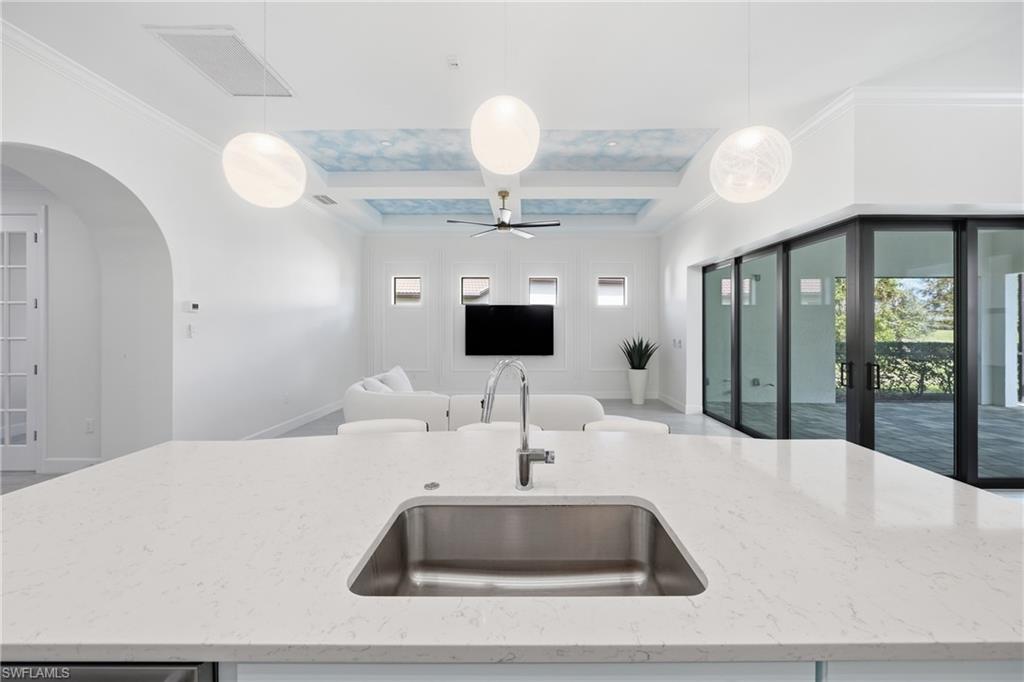 Light-filled kitchen designed for both style and function, featuring freshly painted cabinetry, an updated island with bar seating, and contemporary lighting. The open design creates a natural hub for entertaining while maintaining a sleek, move-in-ready feel.