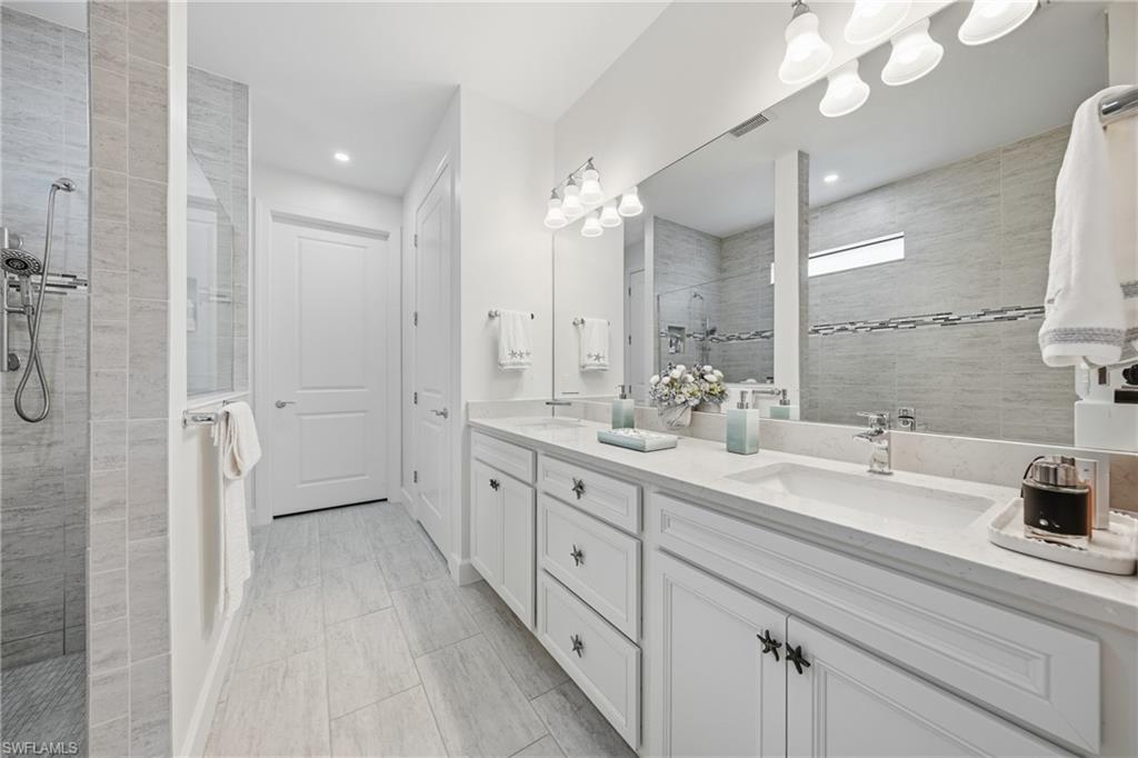 Primary bathroom featuring dual vanities, fresh paint, updated lighting, and a clean, well-maintained layout designed for everyday comfort.