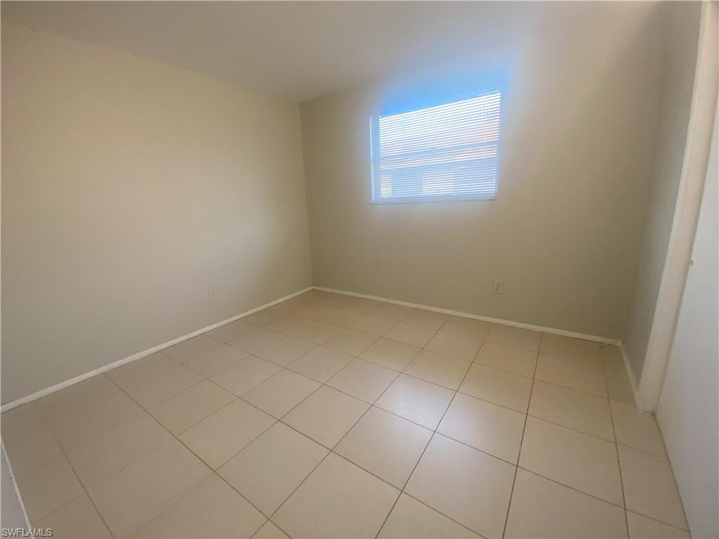 Empty room featuring baseboards and light tile patterned floors