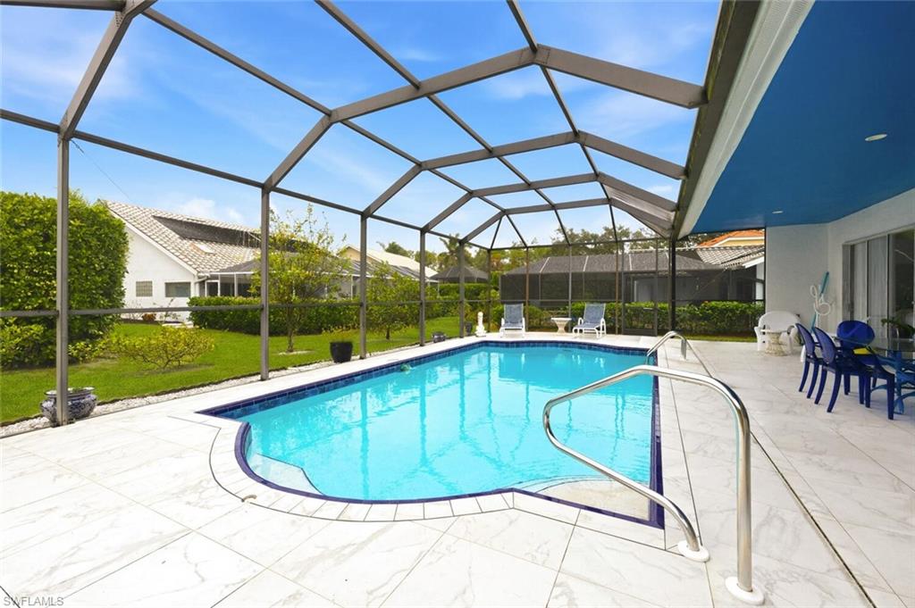 Swimming pool with a sunroom, a lawn, glass enclosure, and a patio area