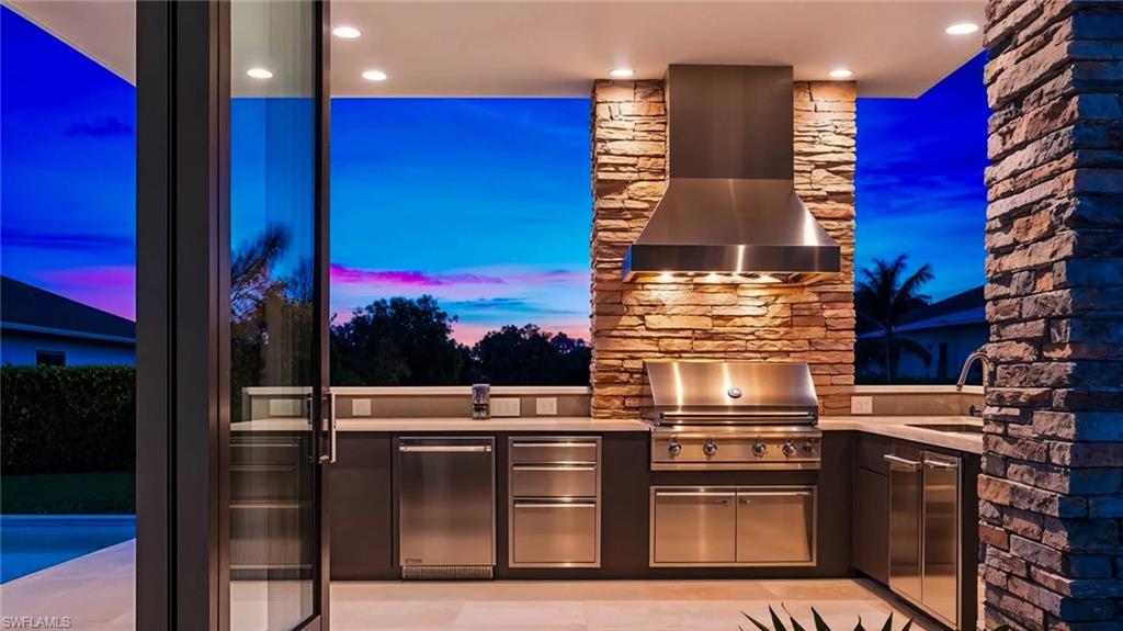 Photos are of a similar home by builder and are for illustrative purposes only. View of optional finishes for outdoor patio / terrace featuring area for grilling with Alfresco Grill.