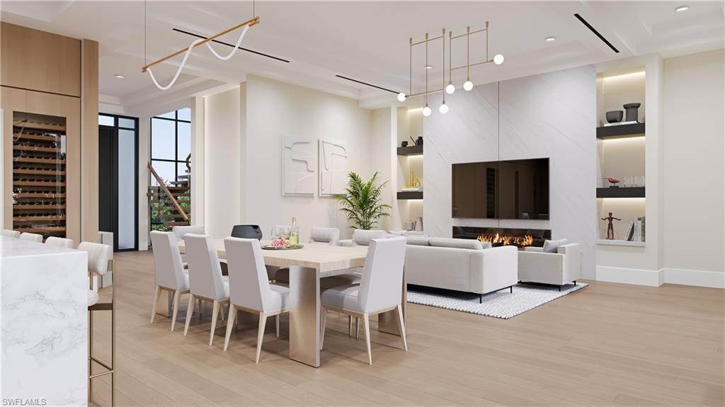 Architectural rendering. Plans and finishes can be customized. Dining area featuring light wood finished floors, beverage cooler, a fireplace, stairway, and recessed lighting.