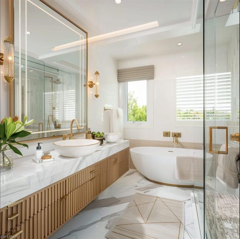 Photos are of a similar home by builder and are for illustrative purposes only. Full bathroom featuring a stall shower, vanity, a freestanding bath, and recessed lighting.