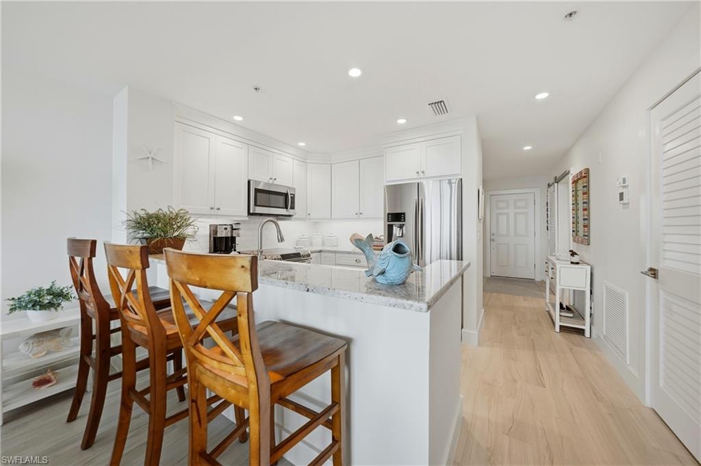 Open Kitchen with Wood Cabinets, Under Cabinet Lighting, Breakfast Bar and Stainless Appliances, Pantry, Tile Flooring