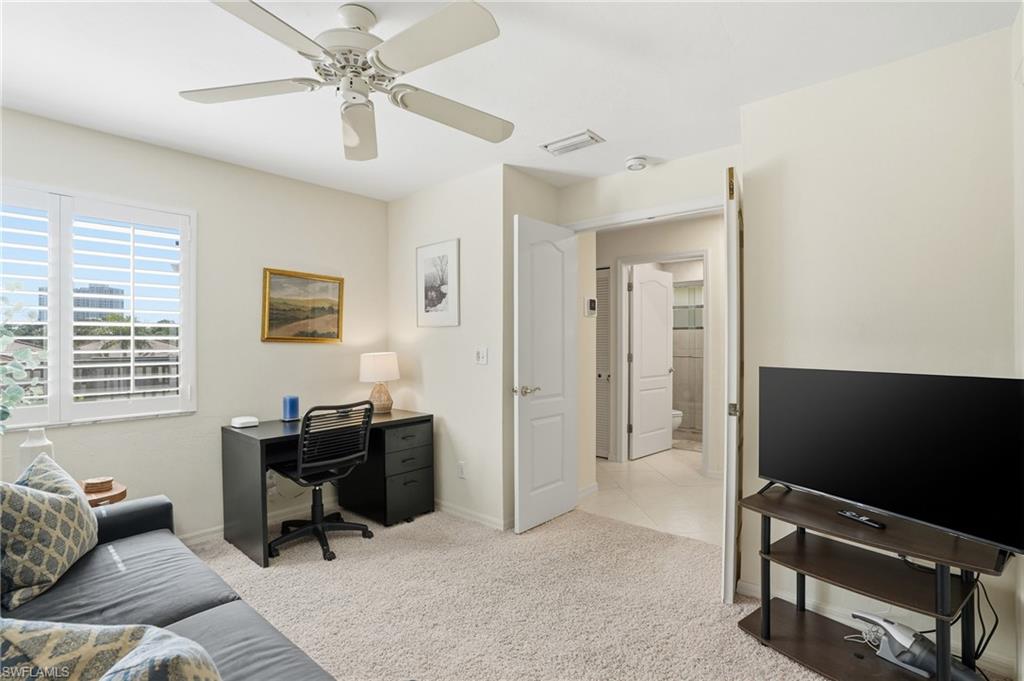 Office area featuring light colored carpet and ceiling fan