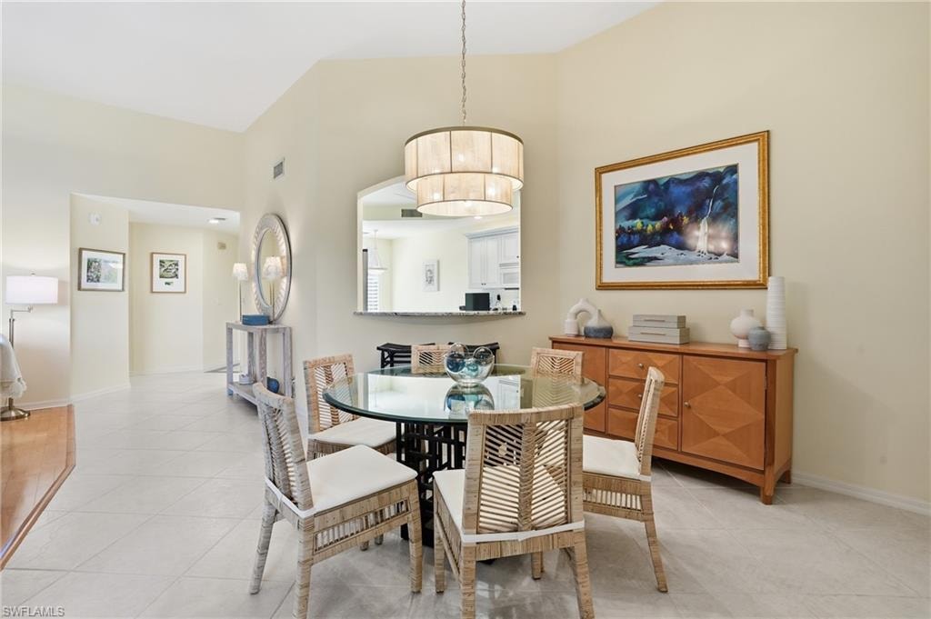 Dining area with a towering ceiling and light tile patterned flooring