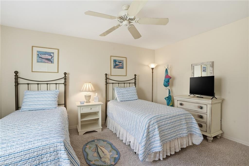 Carpeted bedroom featuring ceiling fan and baseboards