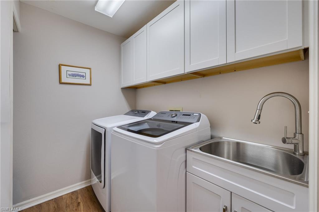 Laundry room complete with newer washer/dryer and new cabinetry and sink.  Additional storage to the left.